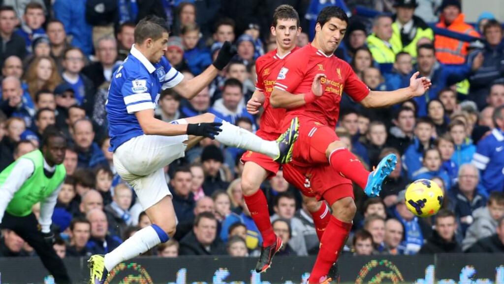 Everton’s Kevin Mirallas (left) catches Liverpool’s Luis Suarez with a high tackle at Goodison Park. Photograph: Peter Byrne/PA Wire
