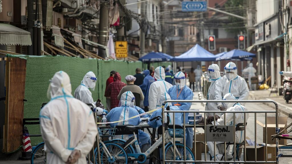 Workers in personal protective equipment  prepare test kits during a Covid-19 lockdown  in Shanghai, China.  Photograph:  Bloomberg