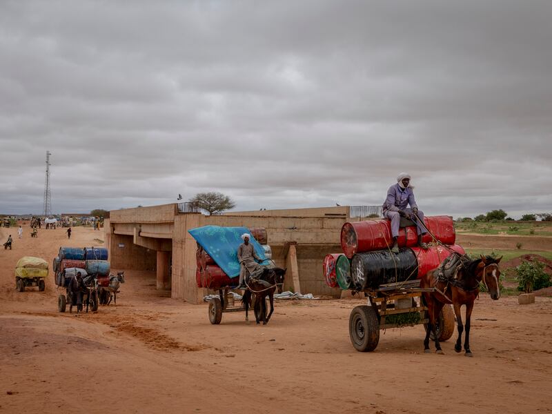 Chadian men who had delivered barrels of petrol to the Sudanese side of the border return with empty barrels to Adre, Chad. Photograph: Ivor Prickett/New York Times