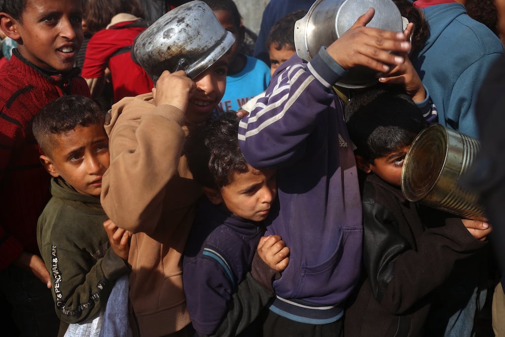 Palestinian children gather to receive aid food being distributed in the central Gaza Strip on Thursday. (Photo by Eyad Baba / AFP)
