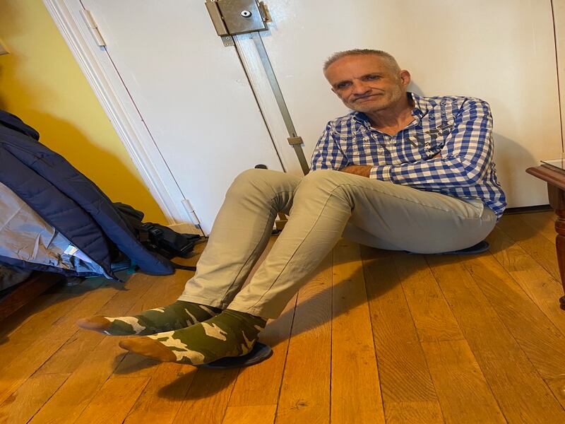 Prisoners were not allowed shoes, only flip-flops without socks even in the coldest winters. Bernard Phelan demonstrates how he used to insulate his body from the cold floor, by sitting on one flip-flop and placing his feet on the other. Photograph: Roland Bonello