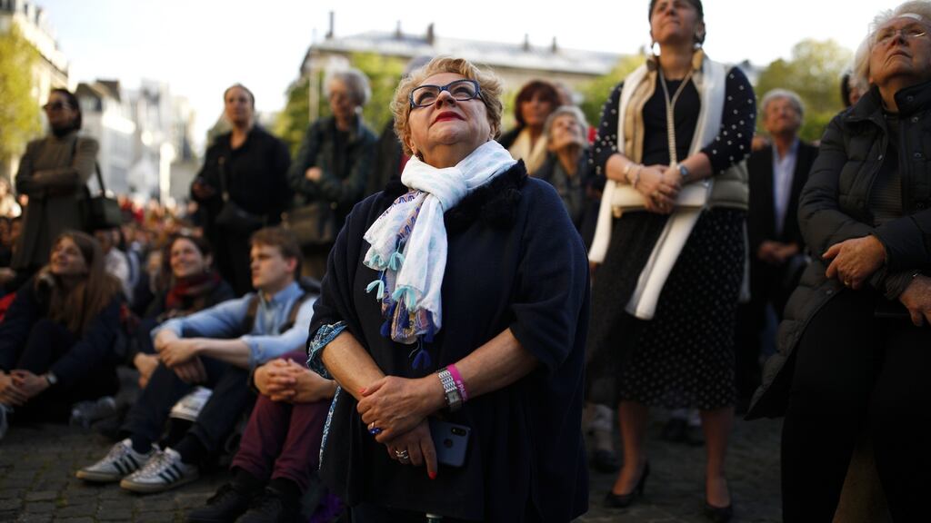 People outside Saint Sulpice participate in the Chrism Mass as part of Holy Week, as bells ring in tribute to Notre Dame Cathedral. Photograph: Ian Langsdon