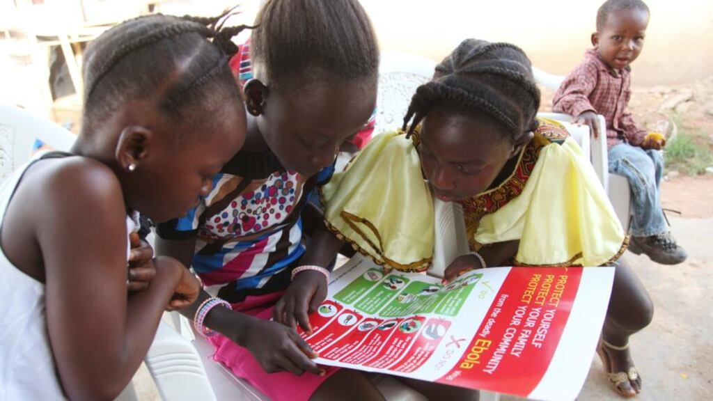 ‘A comparative Irish context could be Carndonagh in Donegal or Ballybay in Monaghan, in 1830s. There is a strong belief in the ‘cure’, faith in traditional healers, loud and long wakes around the body of our loved dead, and a pre-enlightenment animist view of the world.’ Above, girls look at a poster, distributed by UNICEF, bearing information on and illustrations of best practices that help prevent the spread of Ebola virus disease, in the city of Voinjama, in Lofa County, Liberia. Photograph: Ahmed Jallanzo/UNICEF/Reuters