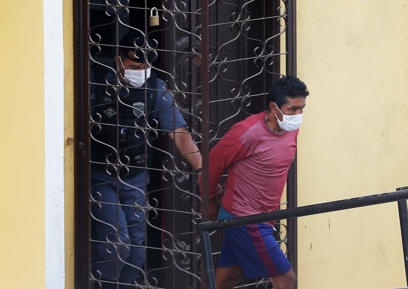 Oseney da Costa de Oliveira is led out a courthouse by military and civil police officers in Atalia do Norte, Amazonas state, Brazil. Photograph: Edmar Barros/AP/PA