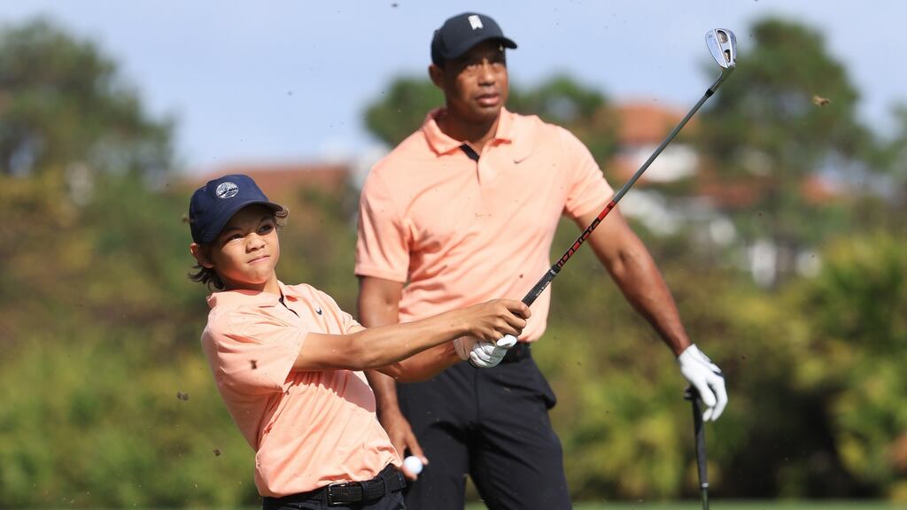 Charlie Woods plays a shot on the second hole as Tiger Woods looks on during round one of the PNC Championship at the Ritz Carlton Golf Club Grande Lakes in Orlando, Florida. Photo: Sam Greenwood/Getty Images