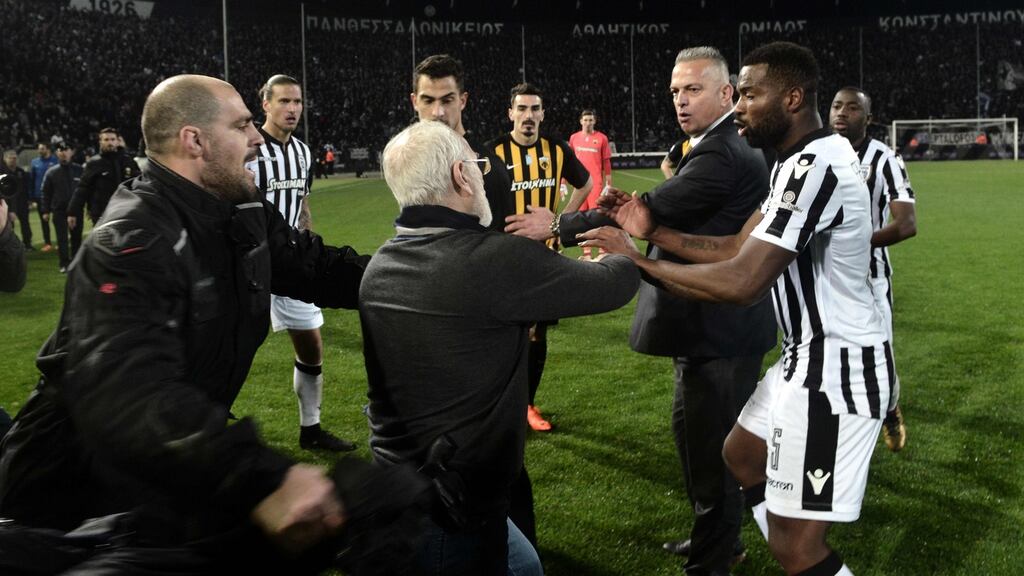 PAOK Salonika owner Ivan Savvides (c) on the Toumba Stadium pitch with what appears to be a gun in a holster. Photograph: Stringer/AFP
