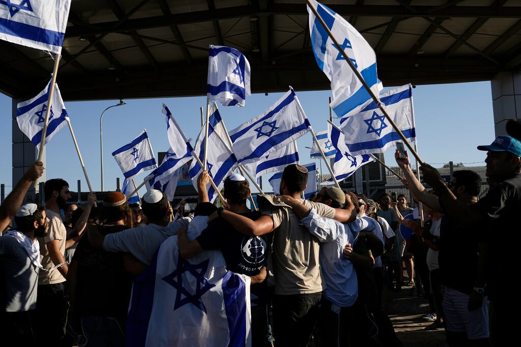 Protesters wave Israeli national flags in support of soldiers being questioned for detainee abuse, outside of the Sde Teiman military base in Israel. Photograph: Tsafrir Abayov/AP
