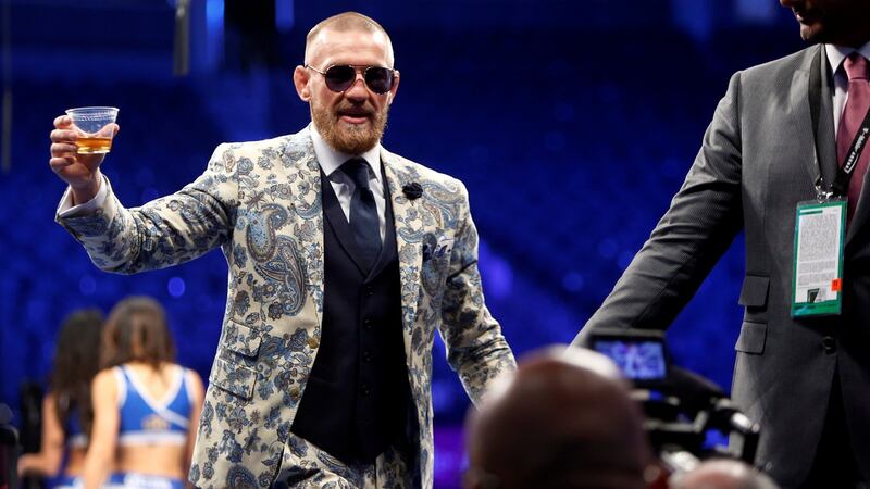 McGregor leaves the press conference with a glass of his own brand whiskey. Photo: Steve Marcus/Reuters