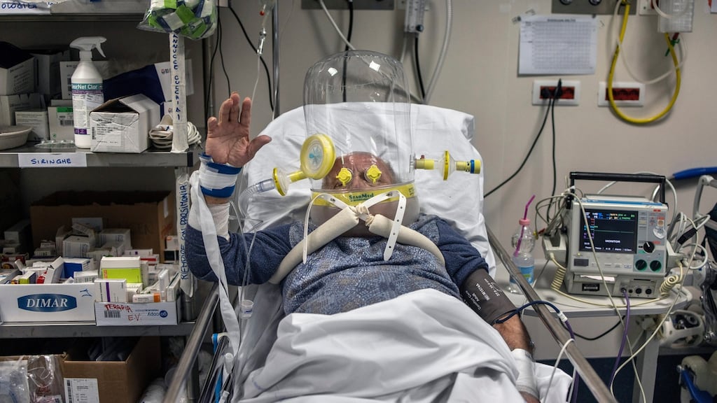 A patient with Covid-19 wears a transparent plastic helmet filled with oxygen at a hospital in Bergamo, Italy. Photograph: Fabio Bucciarelli/The New York Times