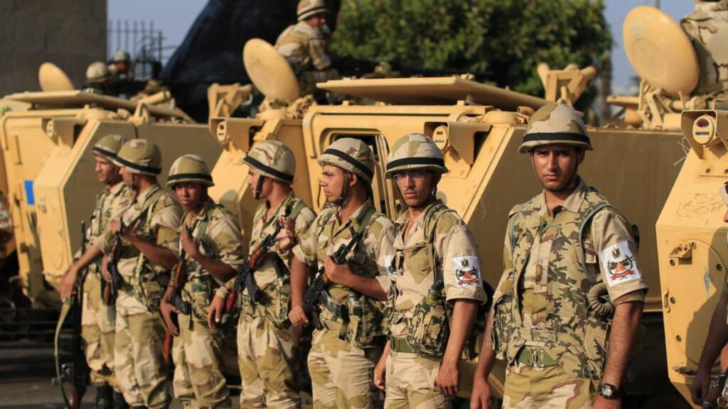 Egyptian army soldiers take their positions near armoured vehicles to guard the entrances of Tahrir Square in Cairo on Monday. Photograph: Hassan Ammar/AP