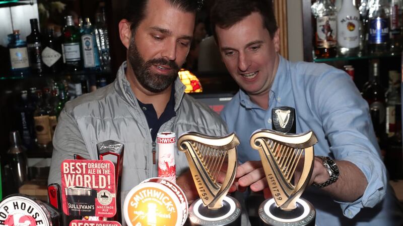 Donald Trump jnr (left) pours drinks and meets locals in the village of Doonbeg. Photograph: Niall Carson/PA Wire