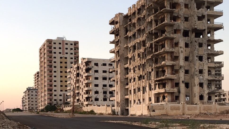 Buildings in al-Waer, Homs, damaged in the Syrian war, stand alongside others that have emerged unscathed to date. Photograph: Michael Jansen