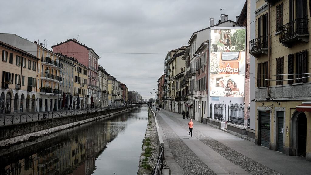 A runner on a nearly deserted street in a normally bustling area of Milan on Thursday, March 12, 2020. In less than three weeks, the coronavirus has overloaded the heath care system all over northern Italy, where daily life has nearly ground to a halt. (Alessandro Grassani/The New York Times)