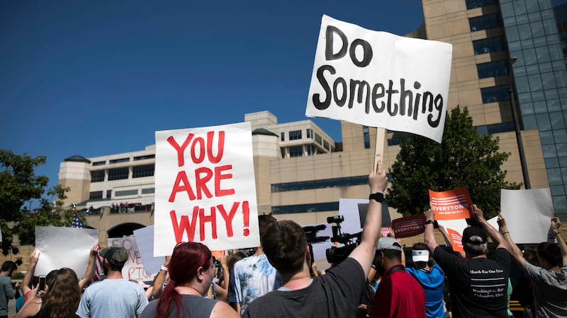 Protesters holds up signs outside Miami Valley Hospital in Dayton, Ohio, as US president Donald Trump visits with victims of Saturday’s mass shooting. Photograph: Maddie McGarvey/The New York Times.