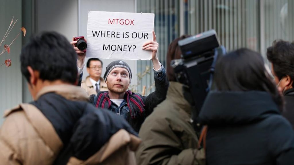 Kolin Burges, a self-styled cryptocurrency trader from London, holds up a placard to protest against Mt Gox, in front of the building where the digital marketplace operator was formerly housed in Tokyo. Photo: Reuters