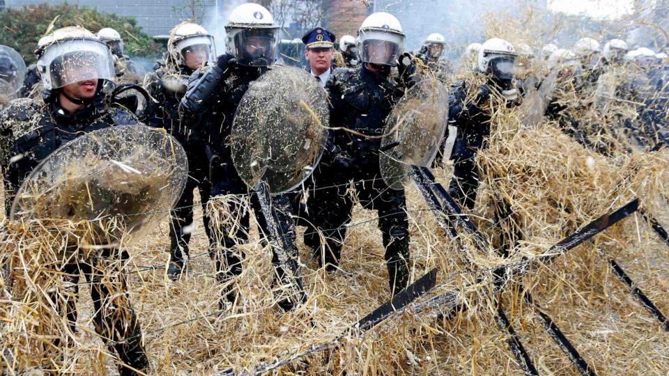 Belgian riot police officers are covered by hay thrown by demonstrators as farmers from all over Europe take part in a demonstration an emergency meeting at the EU Council headquarters in Brussels. Photograph: Yves Herman/Reuters