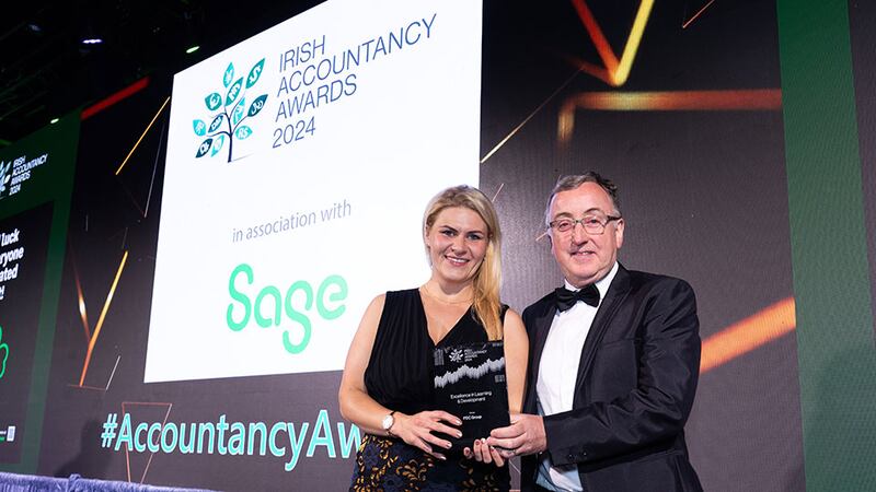 John Gaynor, awards judging coordinator, presents the excellence in learning & development award to the Marta Oliveira, FDC