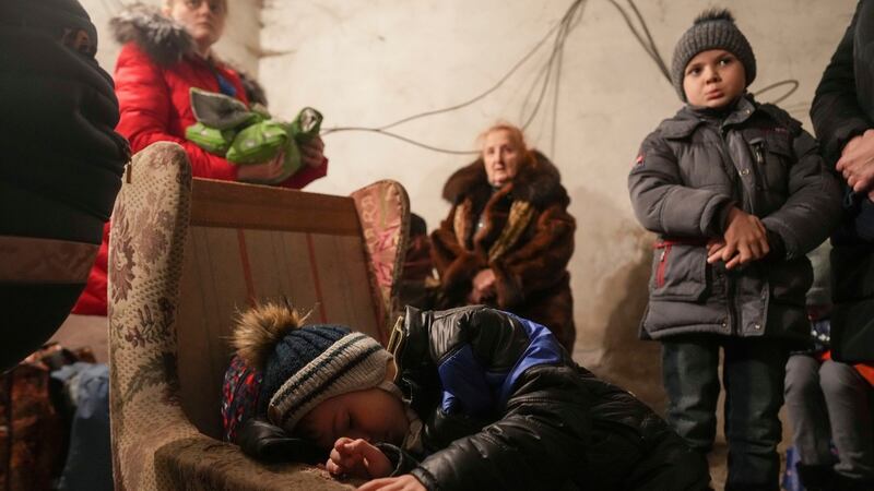 A child sleeps in an armchair as others stand around in a shelter during Russian shelling, in Mariupol, Ukraine, on February 24th, 2022. Photograph: AP Photo/Evgeniy Maloletka