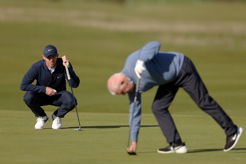 Rory McIlroy of Northern Ireland lines up a putt while looking towards father, Gerry McIlroy. Photograph: Oisin Keniry/Getty
