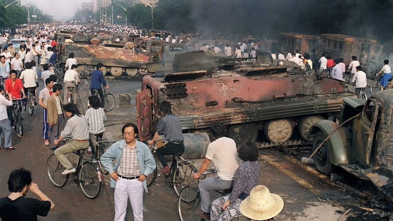 A file image from June 2nd, 1989 showing anti-government protesters near the emains of over 20 armoured personnel carriers burnt out during clashes with soldiers near Tiananmen Square. Photograph: AFP