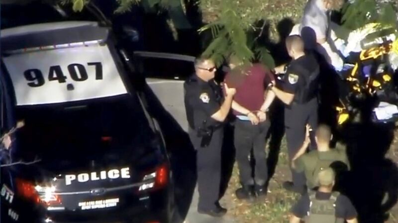 A man in handcuffs is held by police near Marjory Stoneman Douglas High School following a shooting incident in Parkland, Florida, US, in a still image taken from video. Photograph: WSVN.com via Reuters