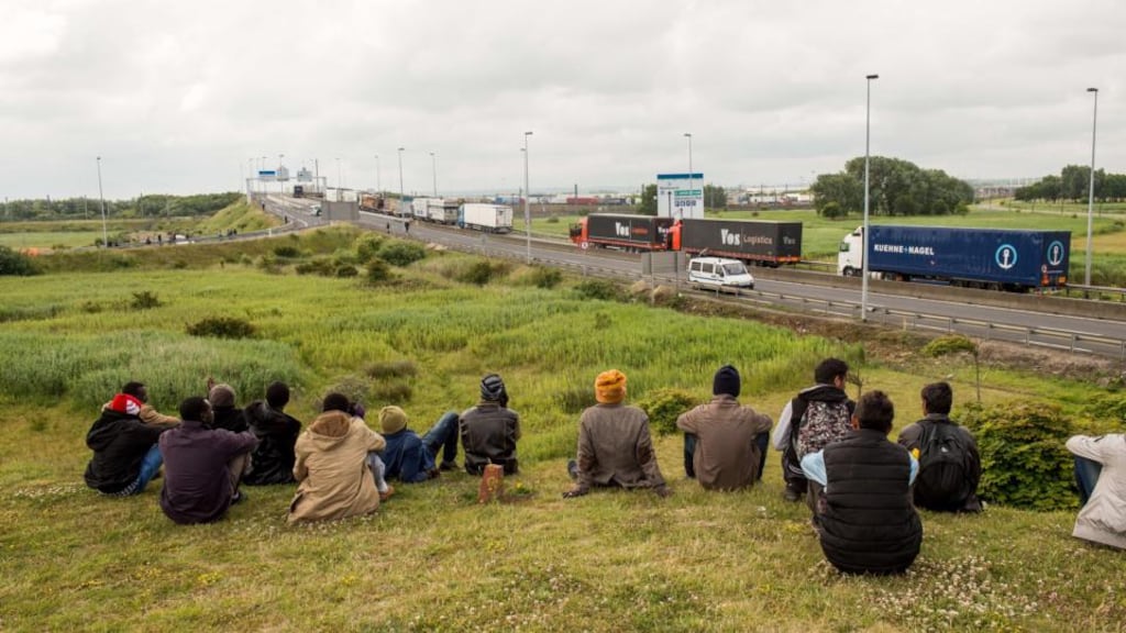 Migrants sit near the A16 highway as they try to access the Channel Tunnel on in Calais, northern France. Photograph: Philippe Huguen/AFP/Getty Images