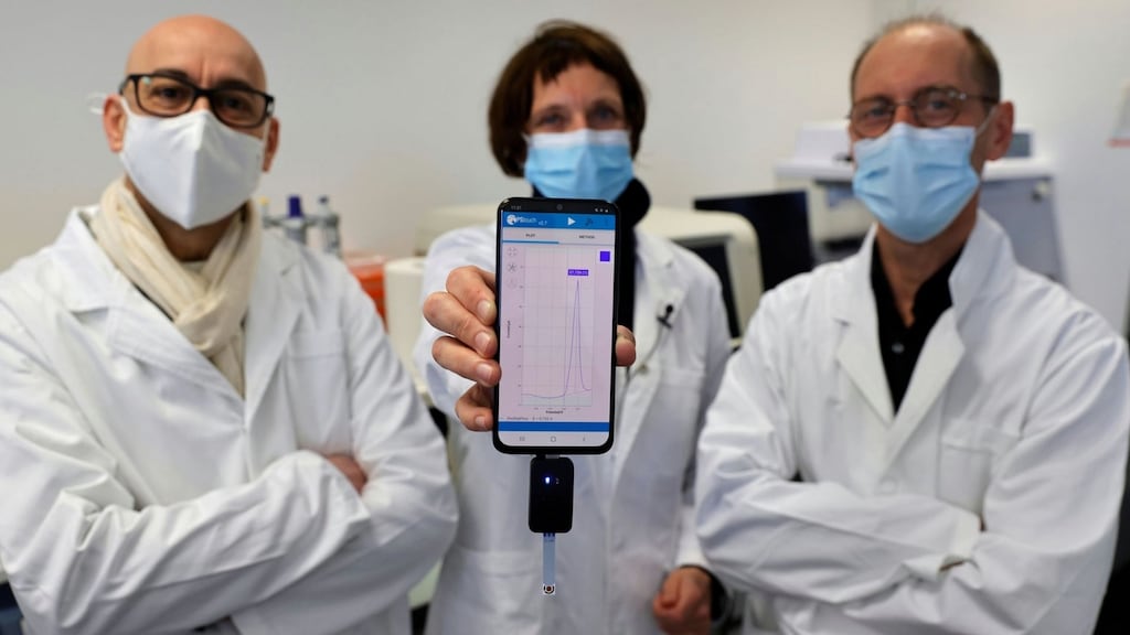 University of Lille researchers Rabah Boukherroub, Sabine Szunerits and David Devos with a smartphone showing CorDial-1 test result. Photograph: Pascal Rossignol/Reuters