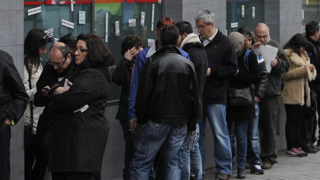 People wait outside an unemployment office in Madrid, Spain today. Spanish government figures show that the number of people registered as unemployed edged down by a little under 5,000 in March, the first reduction for the month in five years. Photograph: Andres Kudacki/AP