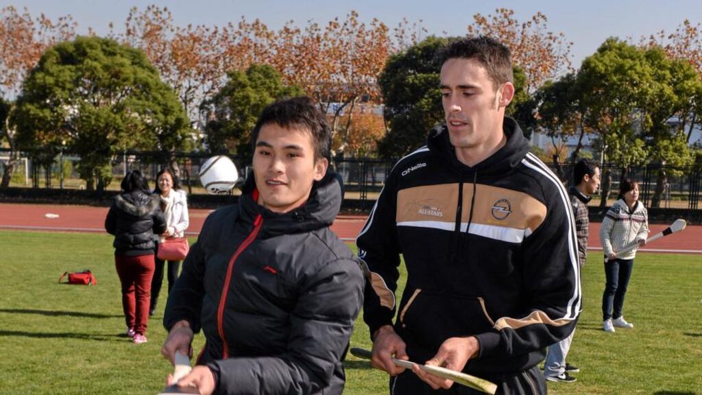Clare’s Brendan Bugler shows Li Cheng Zhi, a student of the Shanghai University, some hurling  skills  at a welcome reception hosted by Shanghai GAA Club. Photo: Ray McManus/Sportsfile