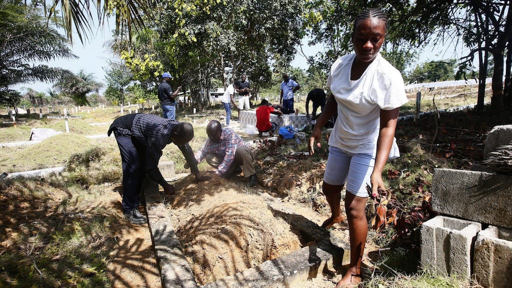 People clean the grave of their loved one, a suspected Ebola victim in 2015, at the Disco Hill safe burial site in Margibi County, Liberia. Photograph: Ahmed Jallanzo/ EPA
