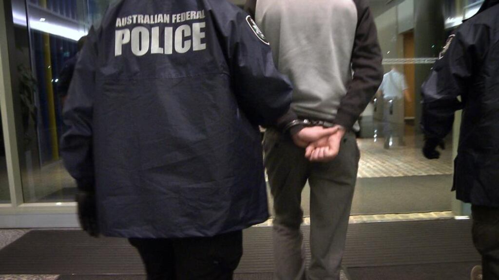 Australian Federal policemen arrest the self-proclaimed leader of the international hacking group LulzSec, the collective that claimed responsibility for infiltrating and shutting down the CIA website. Photograph: Australian Federal Police