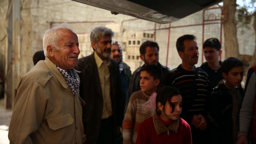 A man mourns as the bodies of his son and grandchildren, reportedly killed in an air strike, are placed in an ambulance in the rebel-held city of Douma, Syria, on Friday. Photograph: Abd Doumany/AFP/Getty Images