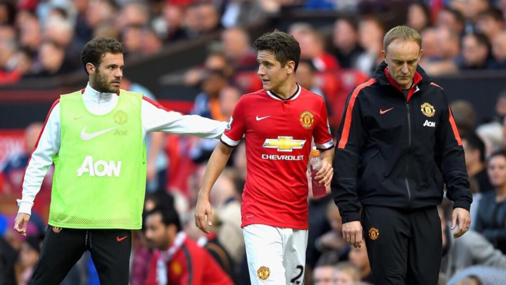 Injured Ander Herrera of Manchester United is consoled by team-mate Juan Mata of Manchester United after being substituted against West Ham United at Old Trafford. Photograph: Laurence Griffiths/Getty Images