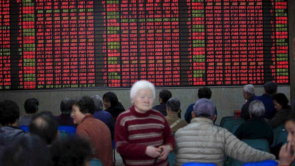 Investors look at an electronic board showing stock information at a brokerage house in Shanghai, China.
