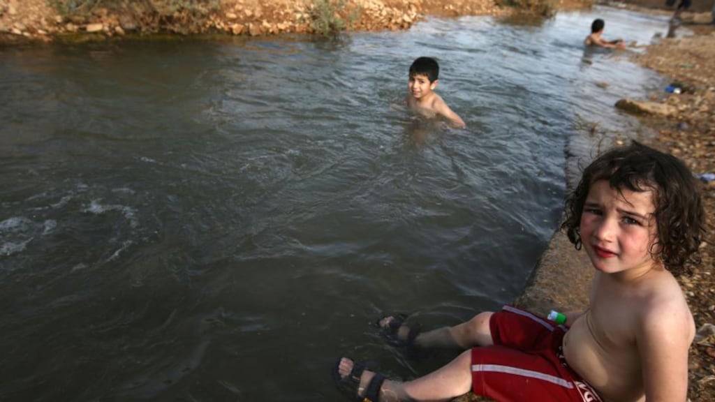 Palestinians jump into a water canal used for irrigation to cool off as temperatures soared to 44 degrees in late May in the West Bank city of Jericho. inhabited for 10,000 years, Jericho vies with Damascus as the oldest city in the world. Photograph: Abbas Momani/AFP/Getty Images