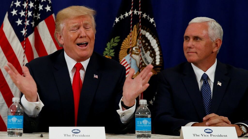 US president Donald Trump, flanked by vice president Mike Pence (R), speaks to reporters after a security briefing at his golf estate in Bedminster, New Jersey. Photograph:Jonathan Ernst/Reuters