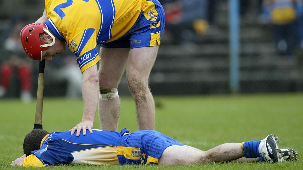 Brian Lohan checks on an injured David Fitzgerald during a Clare NHL game in April 2005. Photograph: Lorraine O’Sullivan/Inpho