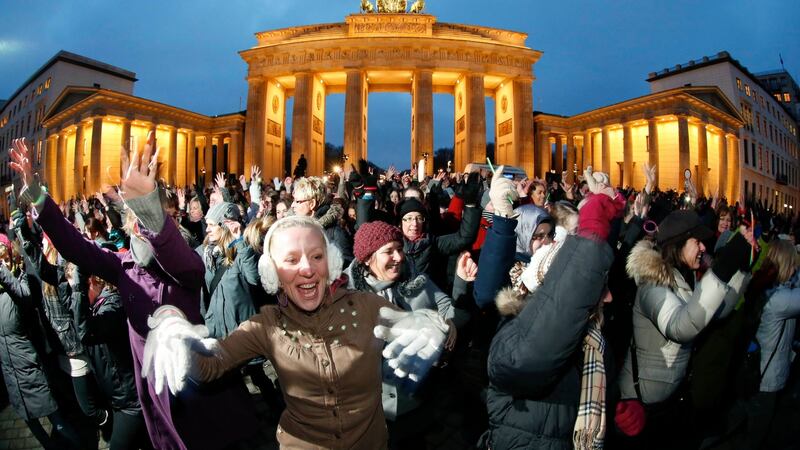 People dance to the theme song of the “One Billion Rising” campaign in front of the Brandenburg Gate in Berlin February 14, 2013. One Billion Rising is a global coordinated campaign aimed to call for an end to violence against women and girls, according to its organisers. REUTERS/Fabrizio Bensch (GERMANY - Tags: SOCIETY)