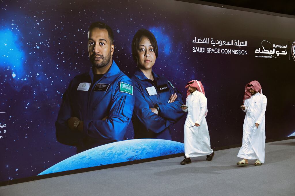 People walk past a poster with the picture of Saudi Space Commission astronauts Ali Al-Qarni (left) and Rayyanah Barnawi, of the Axiom Mission 2, at a government-organised viewing party in Riyadh on May 21st, 2023. Photograph: Fayez Nureldine/AFP via Getty Images