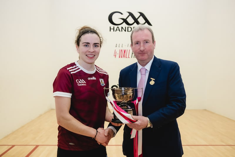 Ciana Ní Churraoin receives her trophy from GAA handball president Conor McDonnell. Photograph: Sheila Marie Rooney Photography