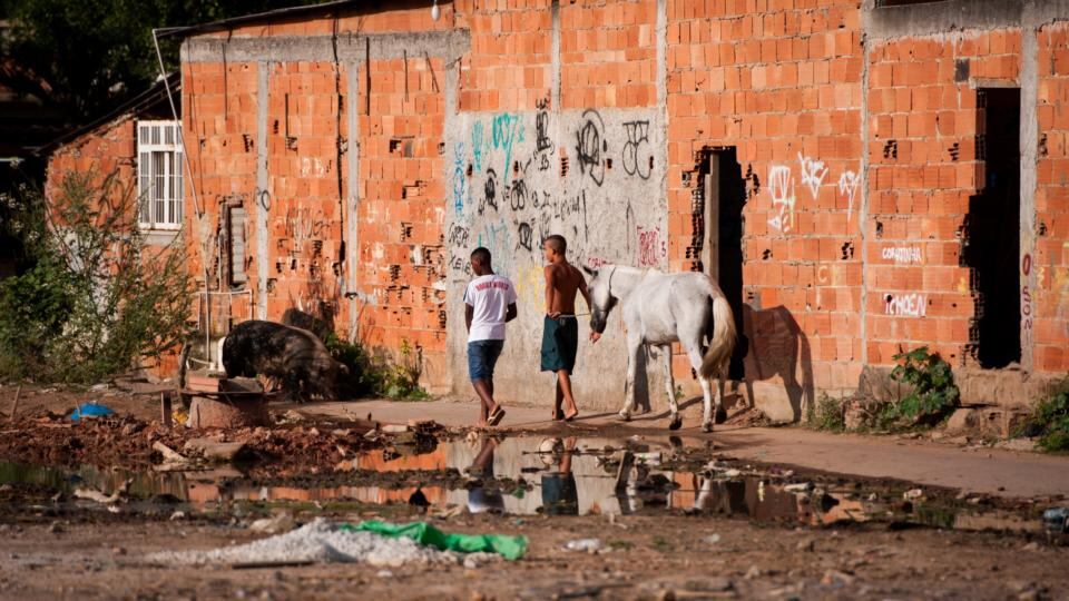 Children walk with horse during a police operation at the Mare slums complex, one of the largest ‘favela’ complexes in Rio. Photograph: Buda Mendes/Getty Images