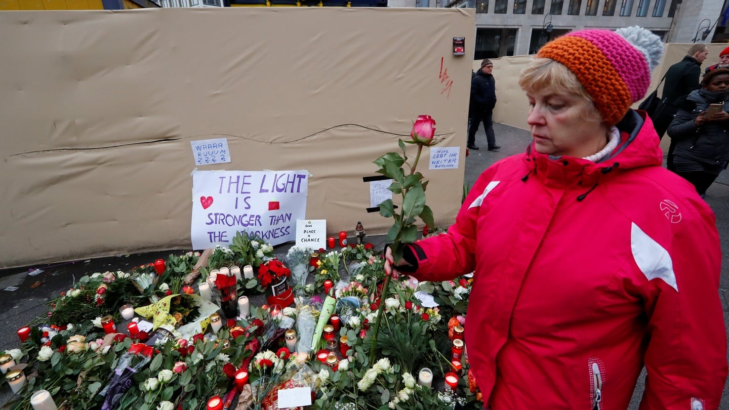 A woman carries a rose at the scene where a truck ploughed into a crowded Christmas market. Photograph: Fabrizio Bensch/Reuters