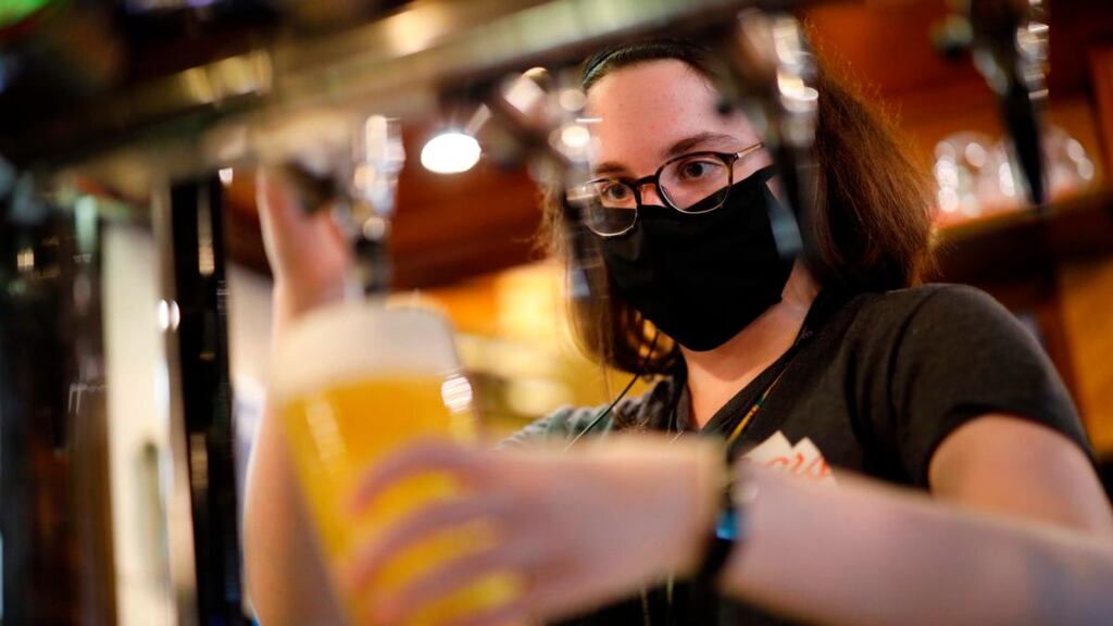 Covid precautions: a masked bartender pours a pint in a London pub. There is mounting evidence coronavirus is airborne, making enclosed indoor spaces more dangerous. Photograph: Tolga Akmen/AFP/Getty