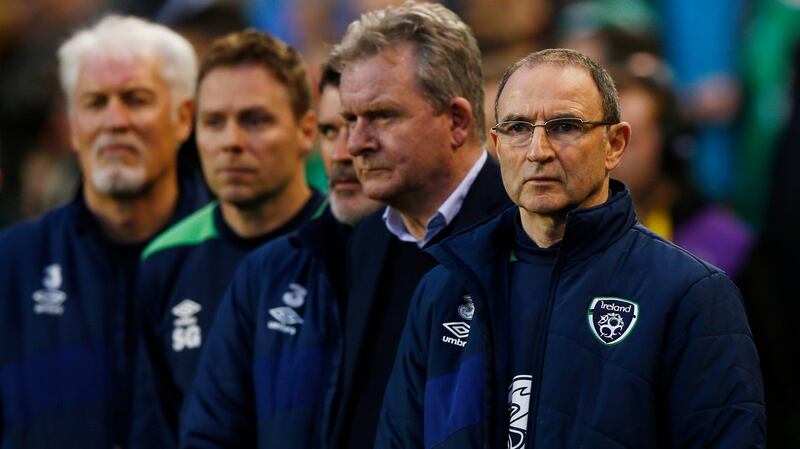 Martin O’Neill and his coaching staff stand for the national anthem before the game. Photo: Peter Cziborra/Inpho
