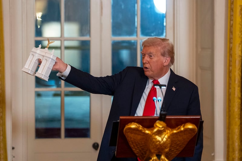 US president Donald Trump with a model of the triumphal arch, which is inspired by the Arc de Triomphe in Paris. Photograph: Doug Mills/New York Times