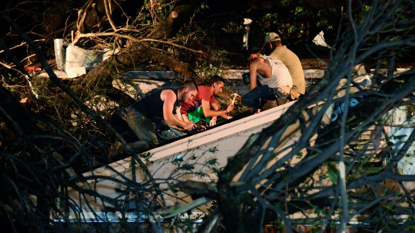 Residents help repair the roof of their neighbour’s house in Shawnee, Oklahoma, damaged by a fallen tree when a tornado swept through yesterday. Photograph: Gene Blevins/Reuters