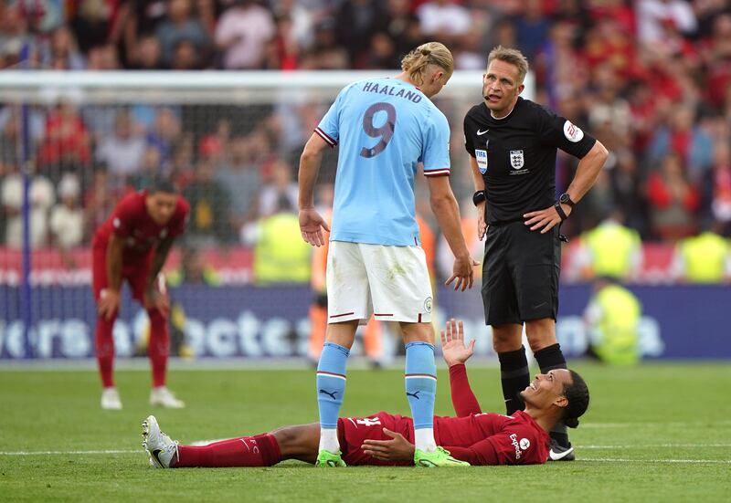 Manchester City's Erling Haaland helps Liverpool's Virgil van Dijk from the ground. Photograph: Joe Giddens/PA