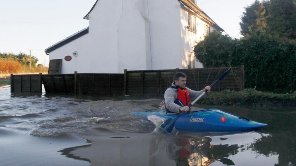 A man paddles his canoe past a flooded property in Yalding, southern England, yesterday . Photograph: Reuters/Luke MacGregor