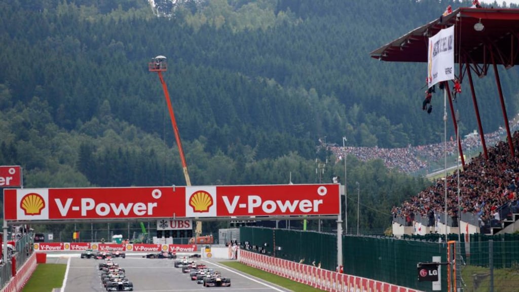 Drivers line up for the start of the Belgian Grand Prix as Greenpeace activists (top right) protest on the roof of the grandstand at Spa-Francorchamps. Photograph: Francois Lenoir/Reuters