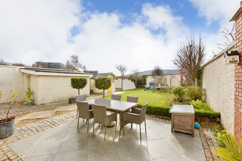 The back garden has a neat lawn, with a big patio area that makes use of the evening sun